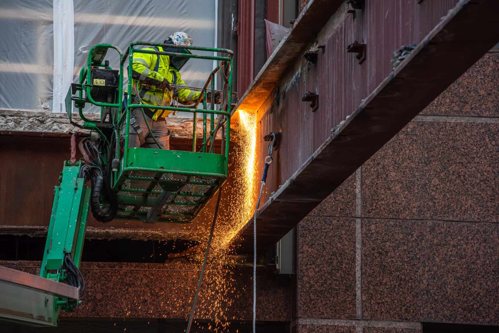 Employee laser cutting steam beam in a lift